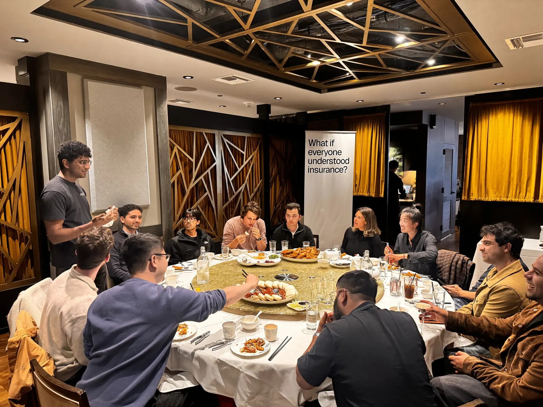 A round-table founder dinner with our banner in the corner