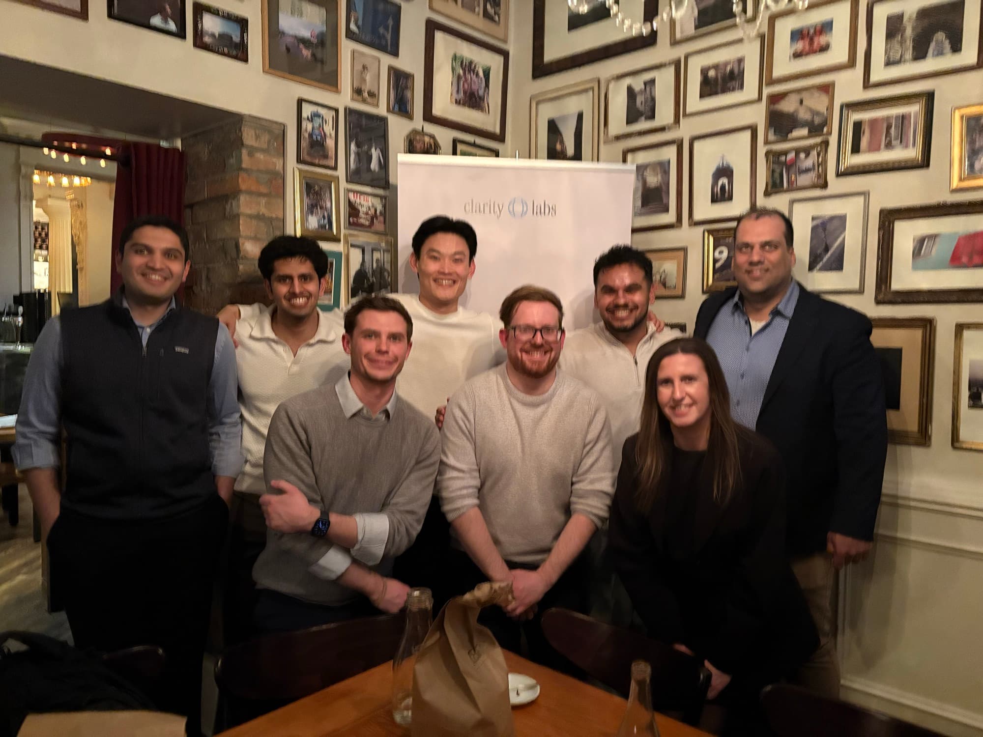 A group around a dinner table with our banner behind them
